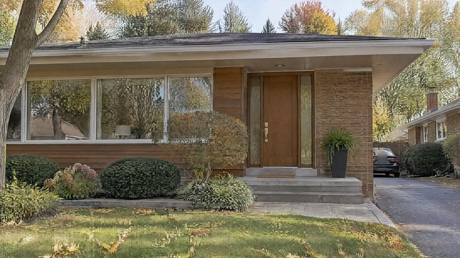 A low brick bungalow with a front garden
